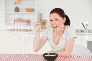 Beautiful woman posing while eating a bowl of pasta
