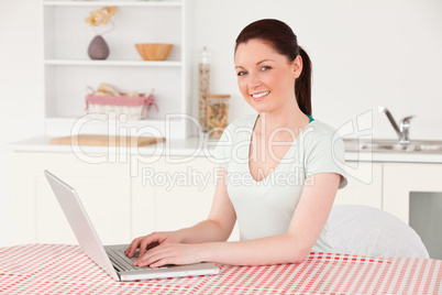 Beautiful woman posing while relaxing with her laptop at lunch t