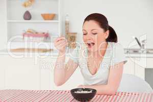Good looking woman posing while eating a bowl of pasta
