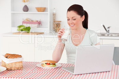 Good looking woman posing with a glass of milk while relaxing wi