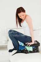 Attractive woman sitting on her suitcase