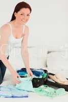 Good looking woman packing her suitcase