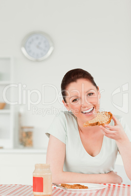 Good looking female preparing a slice of bread and marmalade