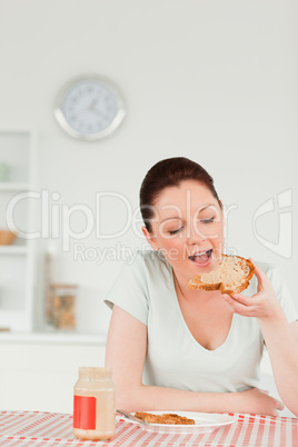 Beautiful female preparing a slice of bread and marmalade