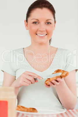 Charming woman preparing a slice of bread and marmalade