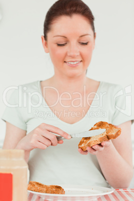 Pretty woman preparing a slice of bread and marmalade