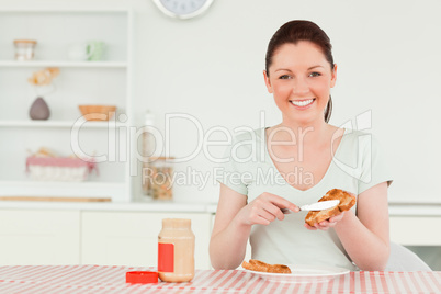 Beautiful woman preparing a slice of bread and marmalade
