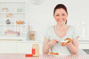 Beautiful woman preparing a slice of bread and marmalade