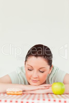 Cute woman posing with a donut and a green apple