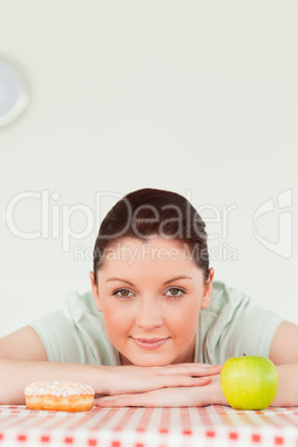 Pretty woman posing with a donut and a green apple