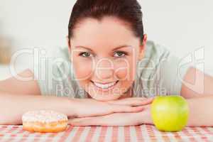 Beautiful woman posing with a donut and a green apple