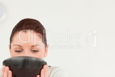 Charming female drinking a bowl of coffee