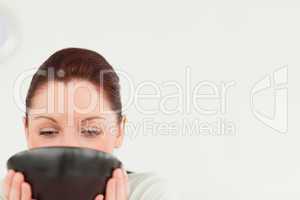 Charming female drinking a bowl of coffee