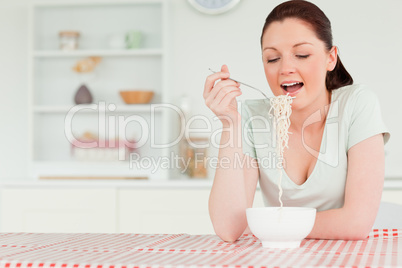 Cute woman posing while eating pasta