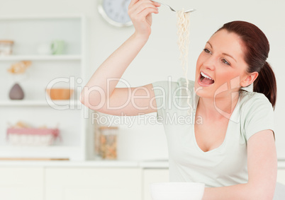 Pretty woman posing while eating pasta