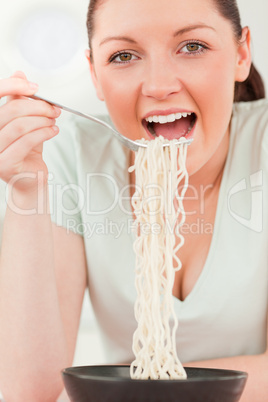 Attractive woman posing while eating pasta