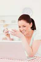 Beautiful woman relaxing on her laptop while drinking a cup of t