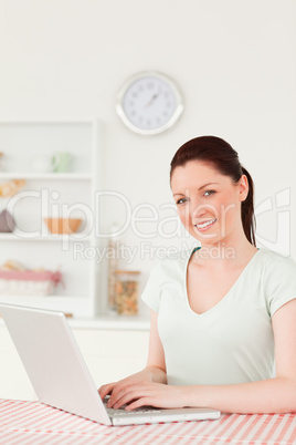 Pretty woman posing while relaxing on her laptop