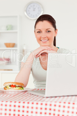 Beautiful woman posing while relaxing on her laptop