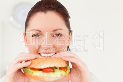 Good looking woman eating a sandwich for lunch