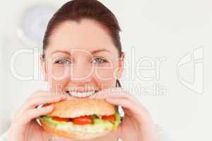 Good looking woman eating a sandwich for lunch