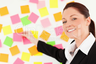 Cute woman putting repositionable notes