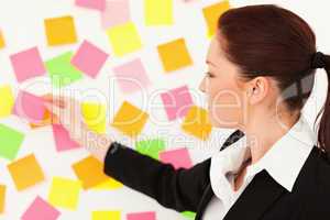 Young woman putting repositionable notes