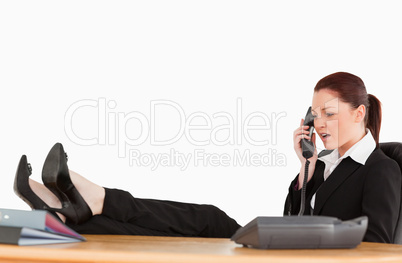 Unhappy business woman on the phone in her office