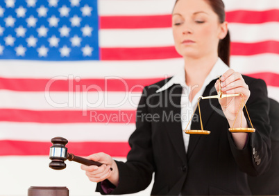 Close up of a young judge knocking a gavel and holding scales of