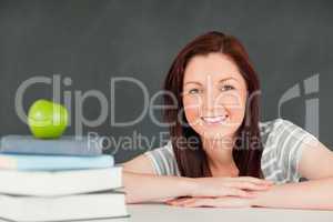 Close up of a student with books and an apple