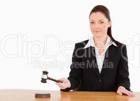 Young judge knocking a gavel smiling at the camera