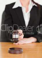Young woman using a gavel while sitting at a desk