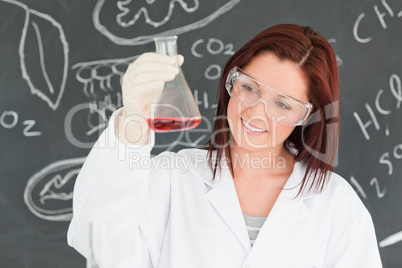 Close up of a cute scientist looking at a conical flask