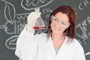 Close up of a cute scientist looking at a conical flask