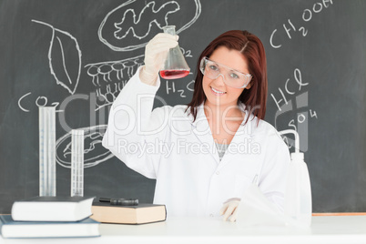 Young scientist showing a conical flask