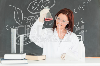Young scientist looking at a conical flask