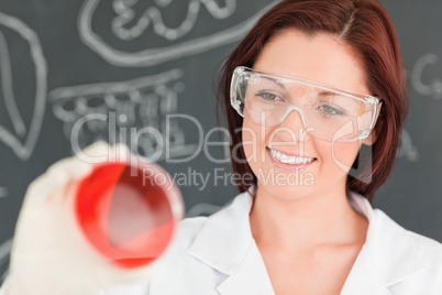Close up of a red-haired scientist looking at a petri dish
