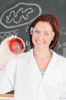 Smiling red-haired scientist looking at a petri dish