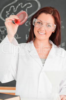 Porttrait of a young woman showing a petri dish