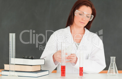 Focused scientist pourring a liquid in a graduated cylindre