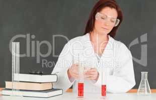 Focused scientist pourring a liquid in a graduated cylindre