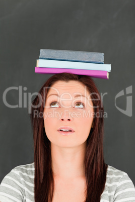 Young woman looking at the books she is wearing on her head