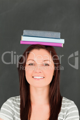 Portrait of a smilling young woman wearing books on her head