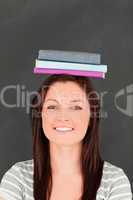 Portrait of a smilling young woman wearing books on her head