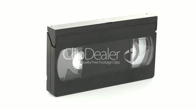 A rotating video tape against a white background