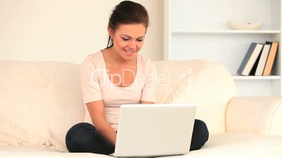 Frau mit Laptop auf einer Couch