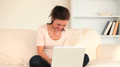 Frau mit Laptop auf einer Couch