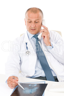 Mature doctor male with x-ray on phone