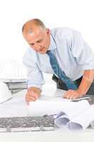 Senior man work on blueprints construction plans