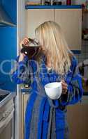 schläfrige blonde Frau trinkt Kaffee aus der Kanne